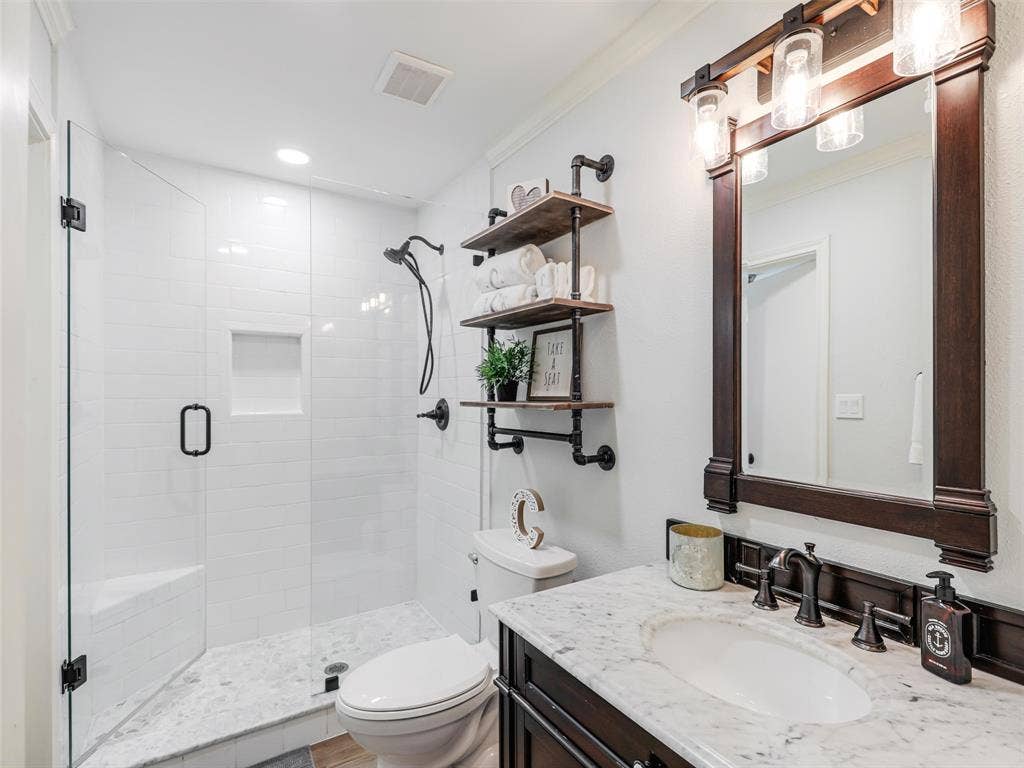 3617 Hackamore Court, Plano, TX 75023 Bathroom featuring a glass-enclosed shower with white subway tile, a built-in shower bench, and a recessed niche