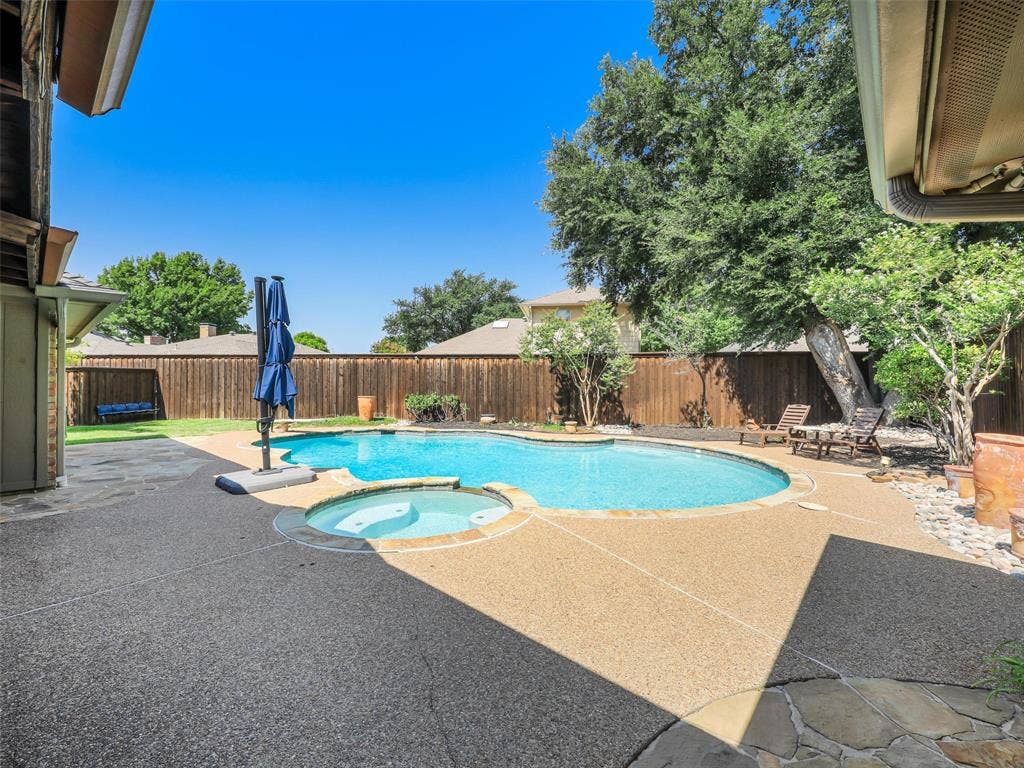 3617 Hackamore Court, Plano, TX 75023 Private backyard oasis featuring a curved pool and integrated spa
