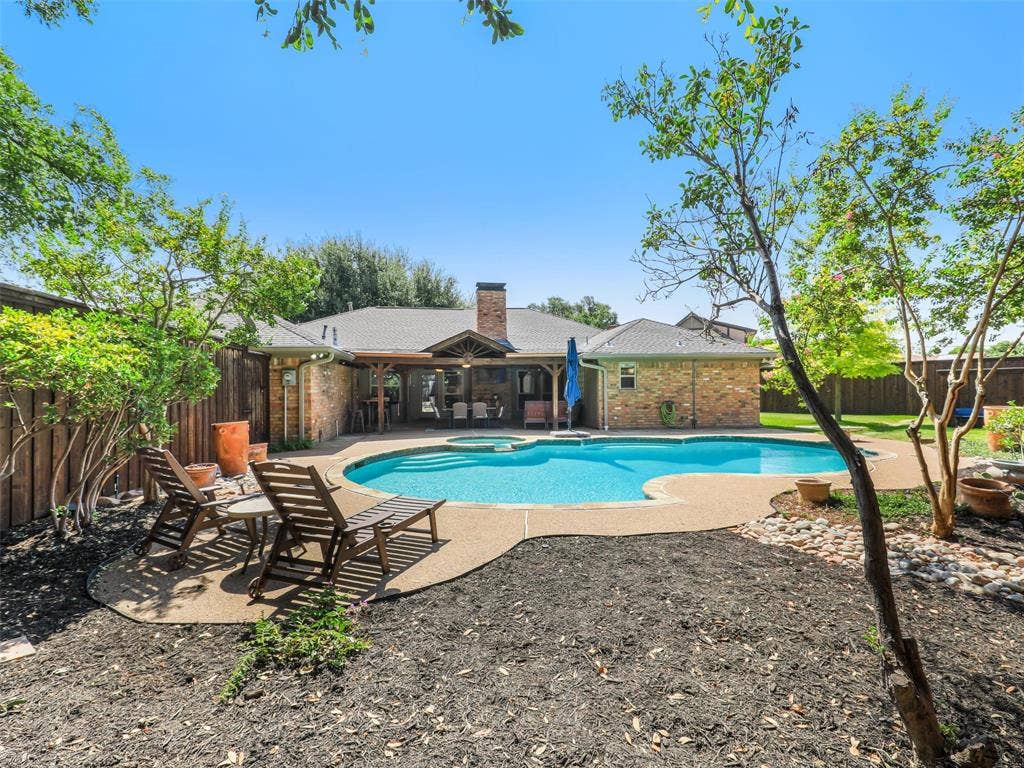 3617 Hackamore Court, Plano, TX 75023 Sparkling resort-style swimming pool with sun loungers and mature shade trees, backed by a brick home with covered patio and oh so private!