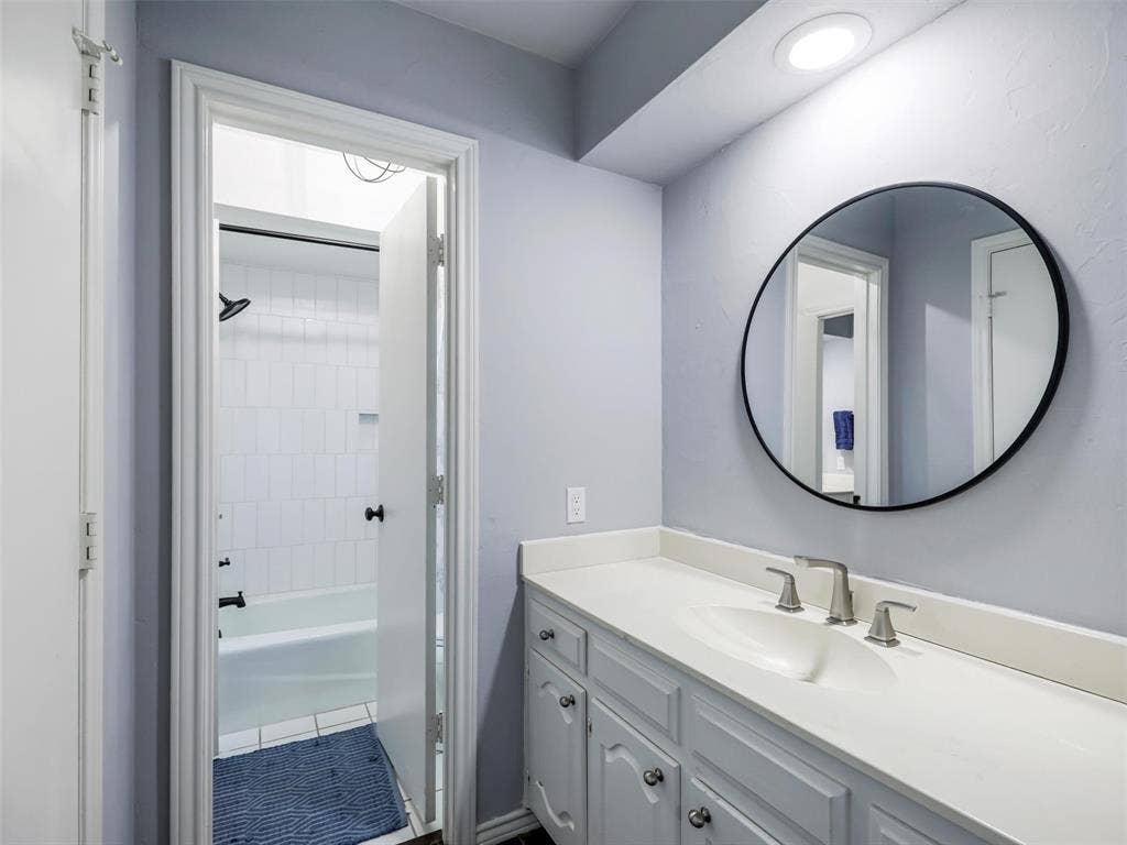 3617 Hackamore Court, Plano, TX 75023 Bathroom vanity in Jack n Jill bath with brushed nickel faucet, and a circular wall mirror