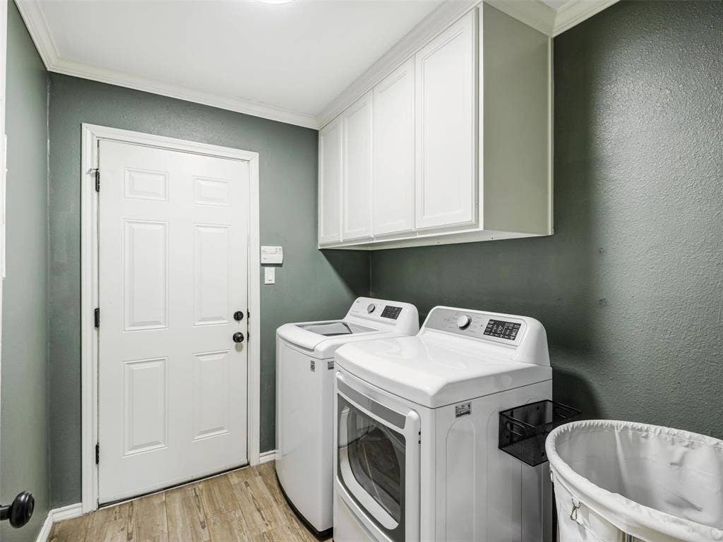 3617 Hackamore Court, Plano, TX 75023 Dedicated laundry area featuring wood-finish flooring, white overhead cabinetry, and crown molding