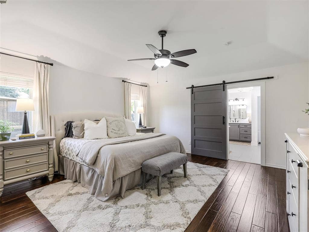 3617 Hackamore Court, Plano, TX 75023 Spacious primary bedroom showcasing hardwood flooring, a ceiling fan with integrated lighting, and abundant natural light from multiple windows