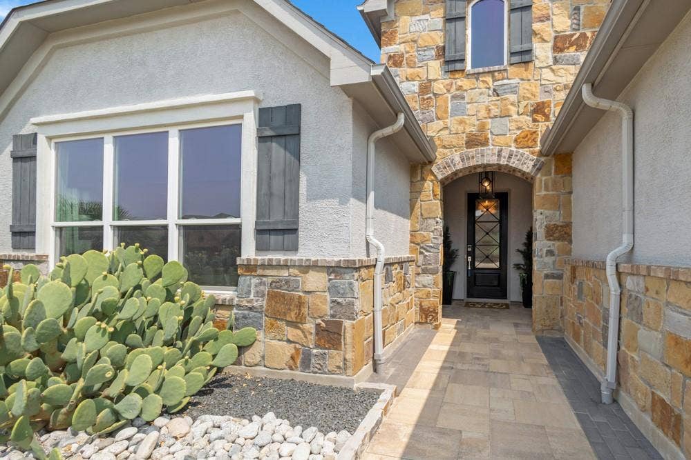Impressive Entry has pavers, stonework and custom front door.