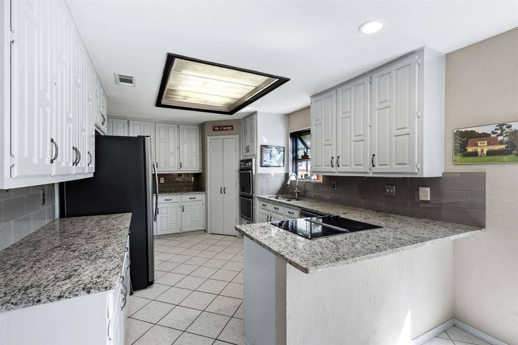 6803 Fernshaw Drive, Dallas, TX 75248 Kitchen featuring white cabinetry, light granite countertops, tile flooring, and integrated cooktop