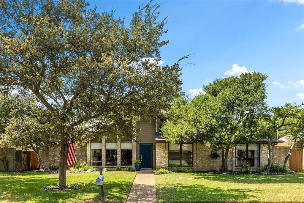 6803 Fernshaw Drive, Dallas, TX 75248 Brick exterior with a prominent front entry, large windows, and mature trees