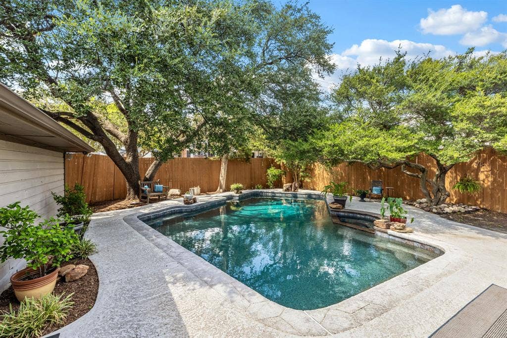 6803 Fernshaw Drive, Dallas, TX 75248 Swimming pool with stone coping and integrated steps, surrounded by a textured concrete patio