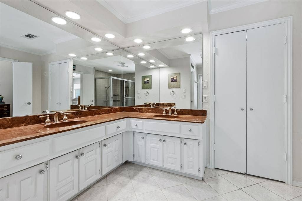 6803 Fernshaw Drive, Dallas, TX 75248 Double vanity with integrated sinks, expansive counter space, white cabinetry, and a full-width mirror with recessed lighting