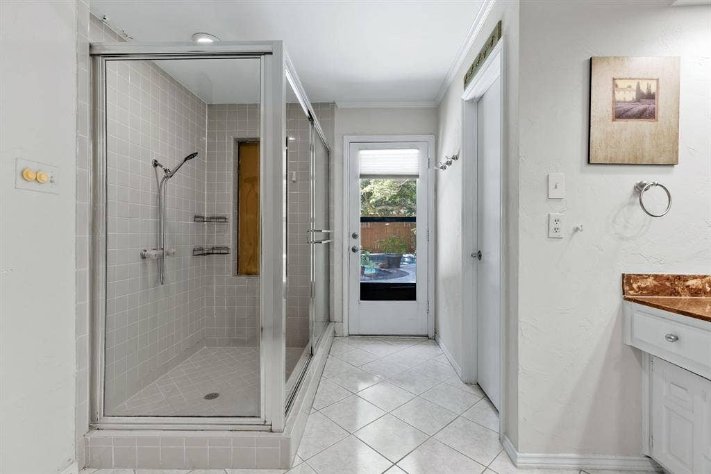 6803 Fernshaw Drive, Dallas, TX 75248 Glass-enclosed shower with tile surround and built-in shelving