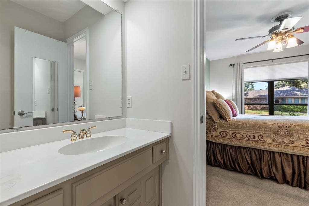 6803 Fernshaw Drive, Dallas, TX 75248 Vanity with integrated sink and brass-finish faucet