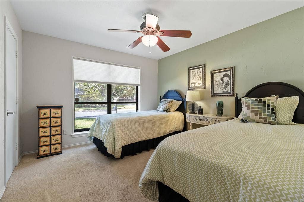 6803 Fernshaw Drive, Dallas, TX 75248 Carpeted room with a ceiling fan, window with blinds, and a light green accent wall