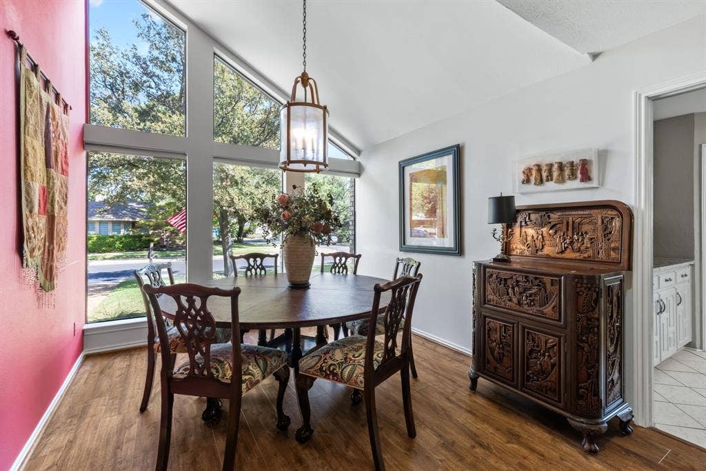 6803 Fernshaw Drive, Dallas, TX 75248 Vaulted ceiling with a hanging lantern fixture, large pane windows, wood-finish flooring, and a brightly painted accent wall