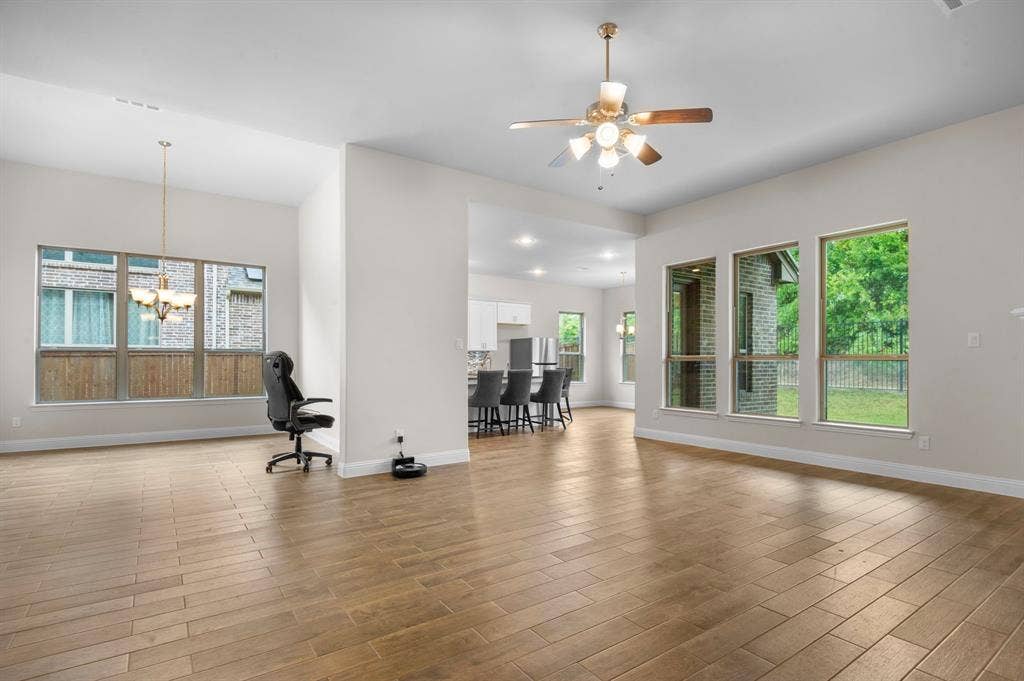 16050 Talamore Lane, Frisco, TX 75035 Great room featuring ceiling fan with notable chandelier and light hardwood / wood-style flooring