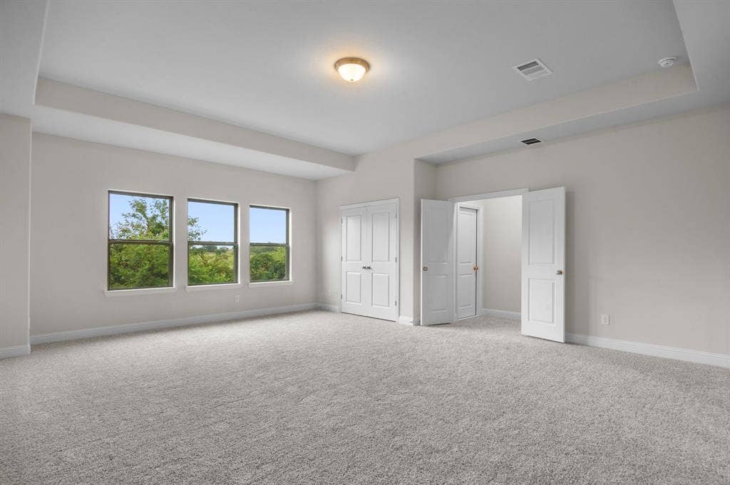 16050 Talamore Lane, Frisco, TX 75035 Unfurnished bedroom with light colored carpet and a raised ceiling