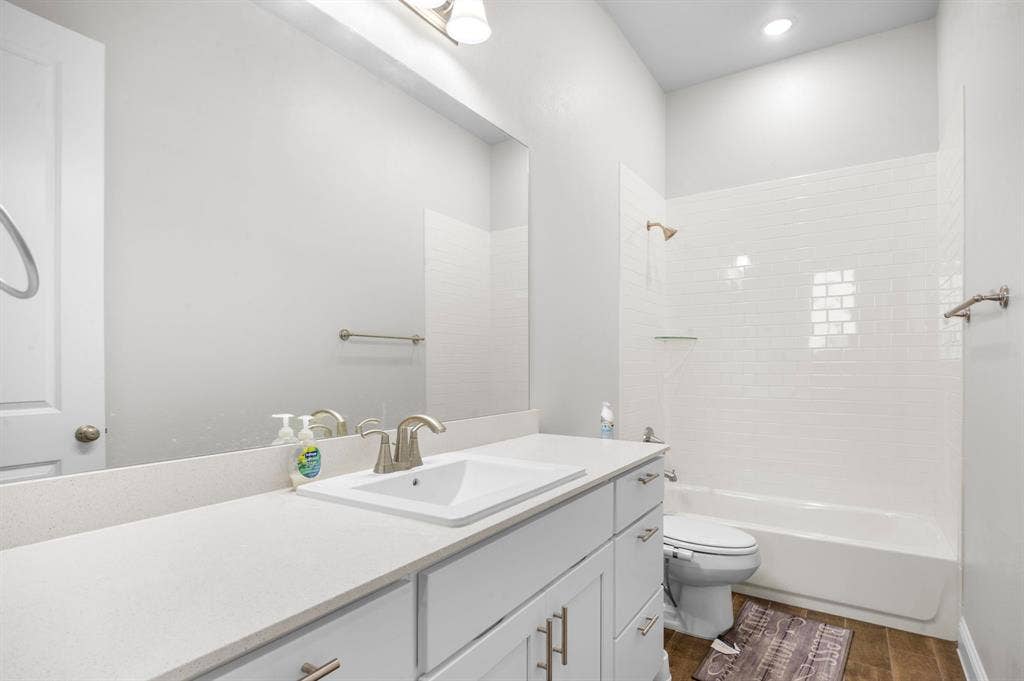 16050 Talamore Lane, Frisco, TX 75035 Full bathroom featuring vanity, toilet, washtub / shower combination, and hardwood / wood-style floors