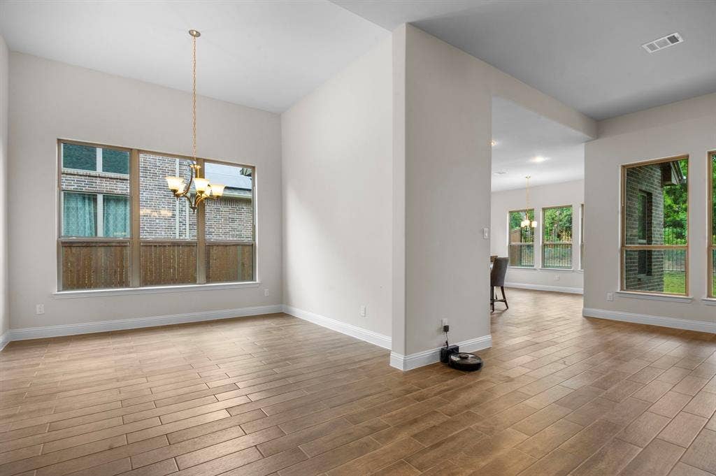 16050 Talamore Lane, Frisco, TX 75035 Unfurnished dining area featuring a notable chandelier and hardwood / wood-style flooring