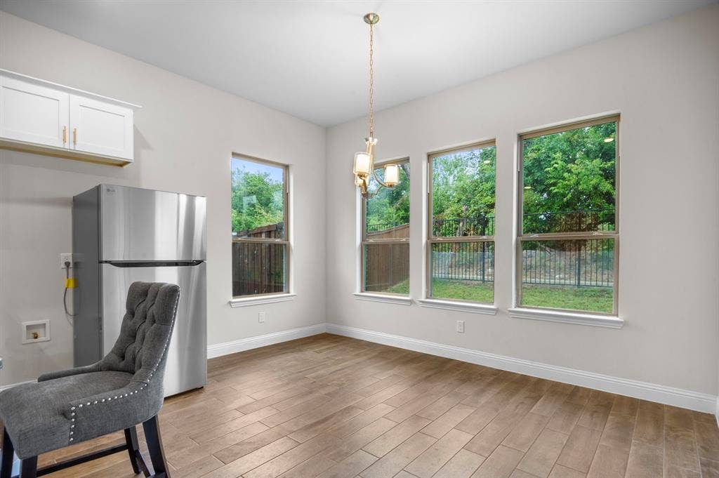 16050 Talamore Lane, Frisco, TX 75035 Kitchen with hardwood / wood-style floors, stainless steel fridge, pendant lighting, and white cabinets