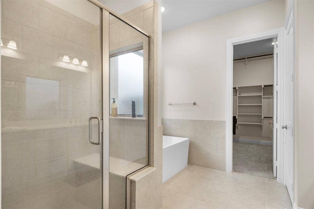 16050 Talamore Lane, Frisco, TX 75035 Bathroom with tile walls, shower with separate bathtub, and tile patterned floors