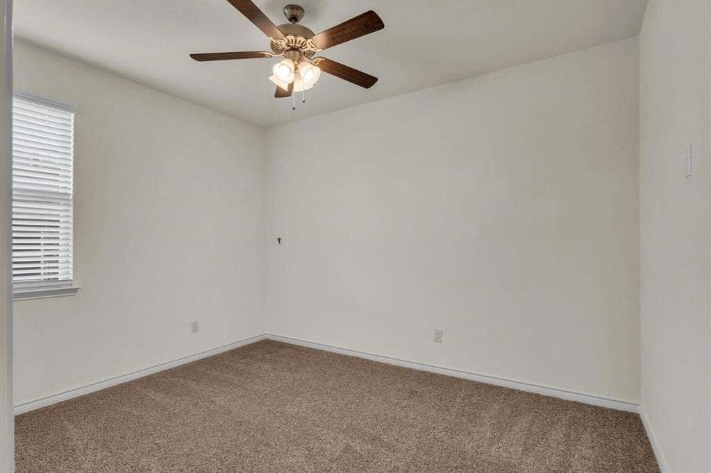 3106 Maverick Drive, Heath, TX 75126 Neutral tone wall paint, textured carpet flooring, window with horizontal blinds, and a ceiling fan with integrated lighting