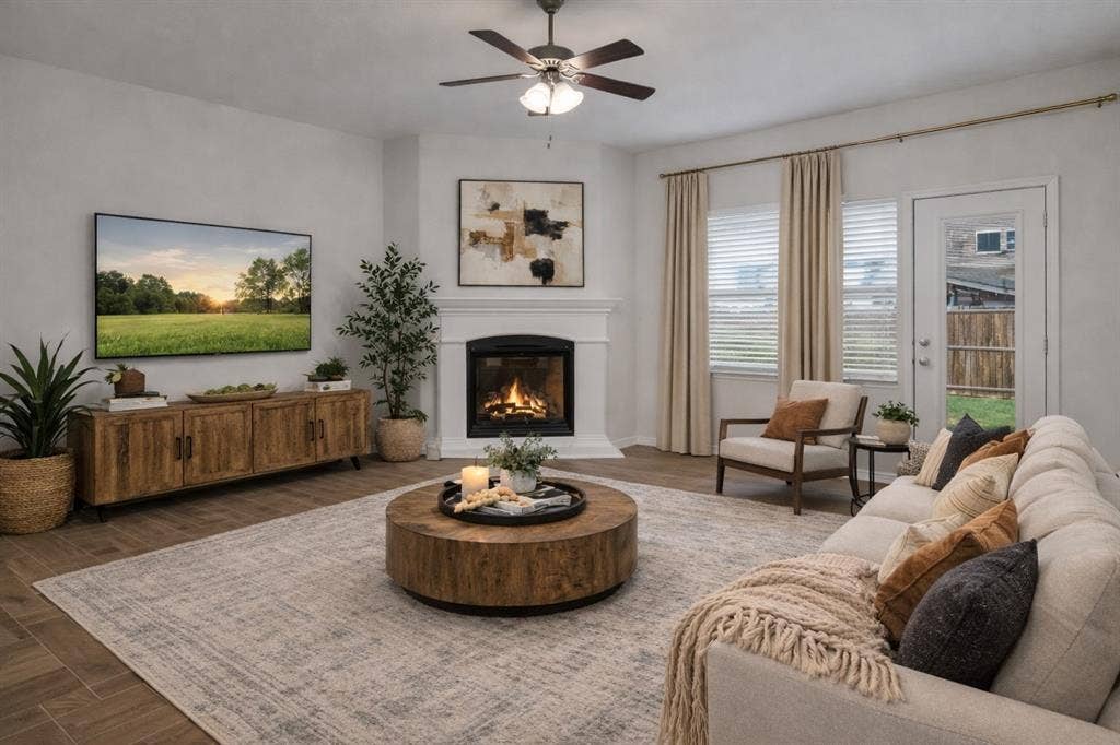 3106 Maverick Drive, Heath, TX 75126 Living area featuring wood-finish flooring, a corner fireplace with a white mantel, and a ceiling fan