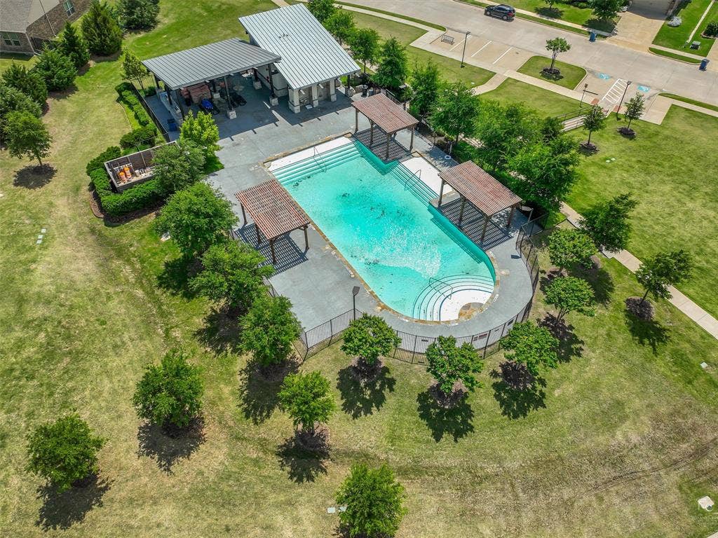 3106 Maverick Drive, Heath, TX 75126 Charming brick-front home featuring a two-car garage, manicured front lawn with established landscaping, concrete driveway, and arched entryway