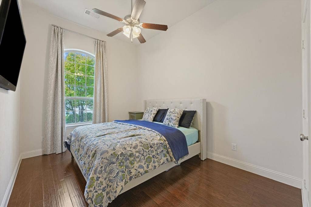 1113 5th Street, Argyle, TX 76226 Third bedroom with hardwood flooring, vaulted ceiling, ceiling fan and a tall arched window overlooking the front yard.
