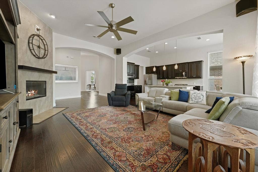 1113 5th Street, Argyle, TX 76226 Spacious family room with a gas fireplace, built-in sound system speakers, hardwood flooring and an open connection to the kitchen.