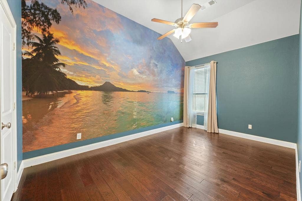 1113 5th Street, Argyle, TX 76226 Secondary bedroom with vaulted ceiling, engineered hardwood flooring, ceiling fan and a large feature wall.
