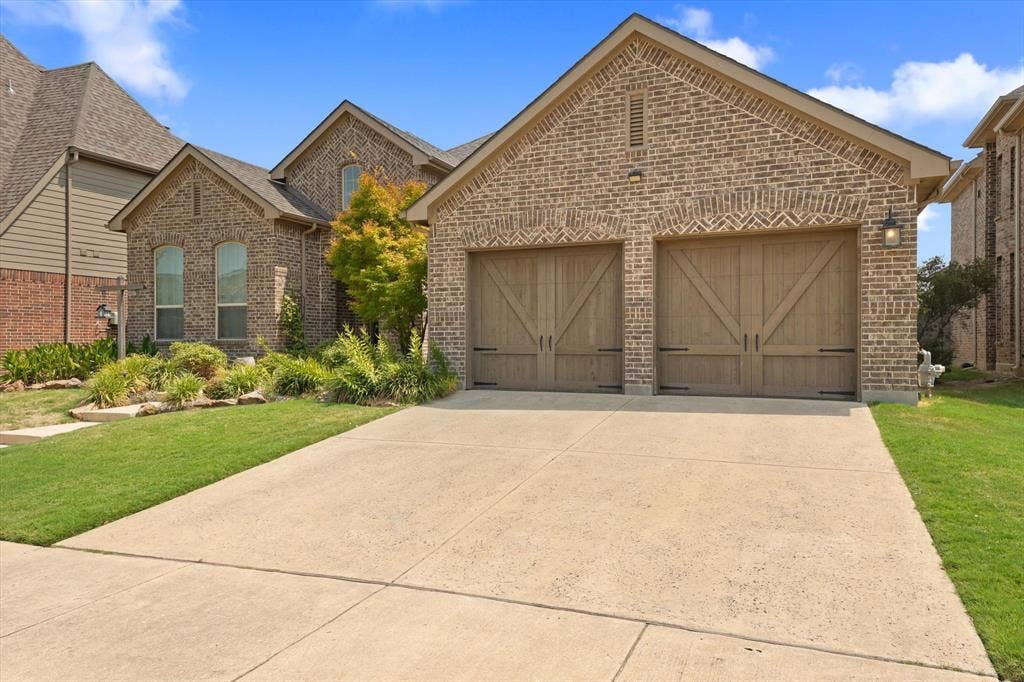 1113 5th Street, Argyle, TX 76226 Three-car garage with separate garage doors and wide driveway, providing additional parking, storage or workspace in this Harvest home.