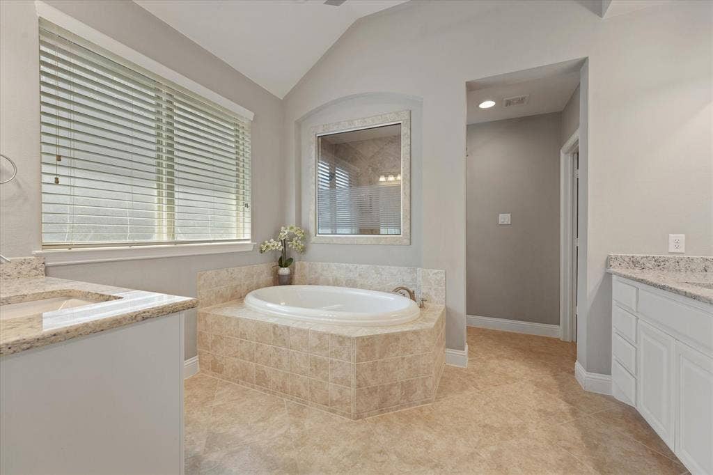 1113 5th Street, Argyle, TX 76226 Primary bathroom with a soaking tub, granite countertops, separate vanities and direct access to the walk-in closet.