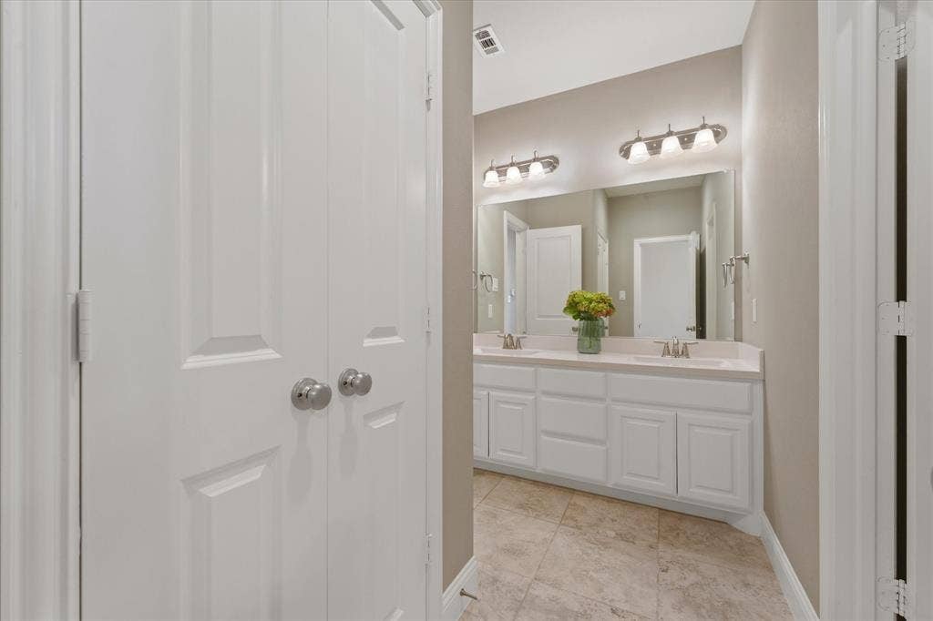 1113 5th Street, Argyle, TX 76226 Dual-sink vanity with generous counter space and storage, positioned between the home’s secondary bedrooms.