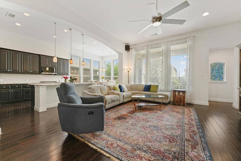 1113 5th Street, Argyle, TX 76226 Light-filled living area with tall windows, open sightlines to the kitchen and breakfast area, and no carpet throughout the home.