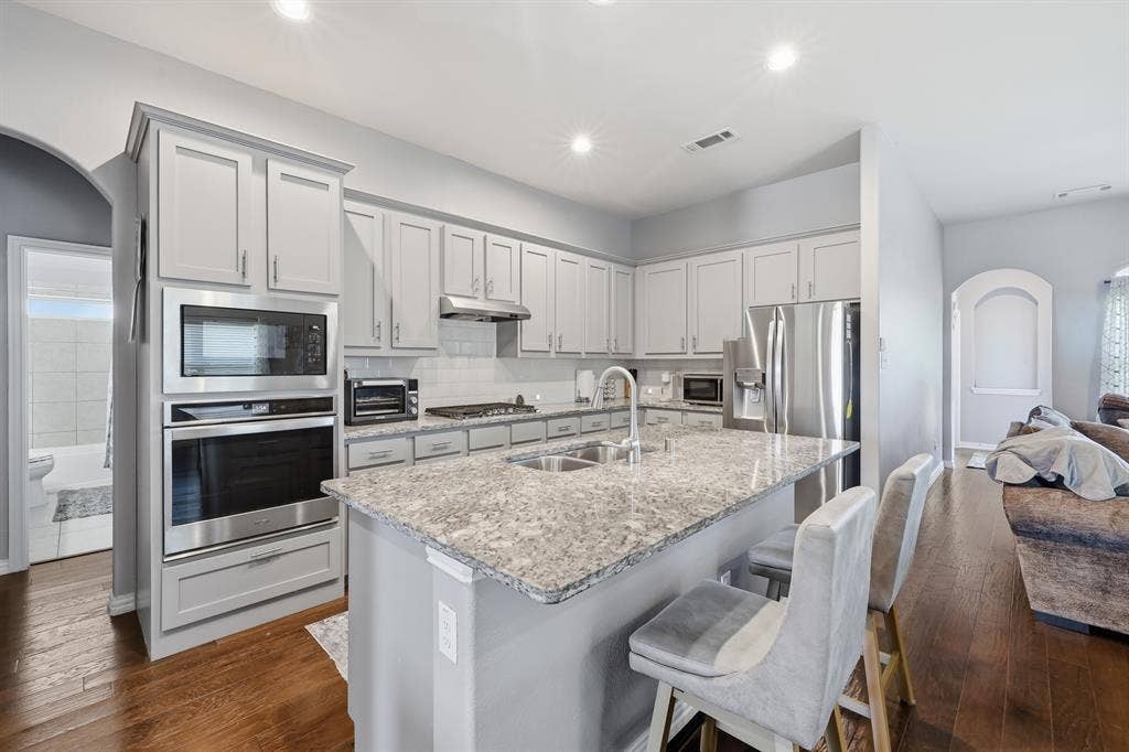 1556 Seminole Drive, Forney, TX 75126 Kitchen featuring light gray cabinetry, stainless steel appliances, and large island