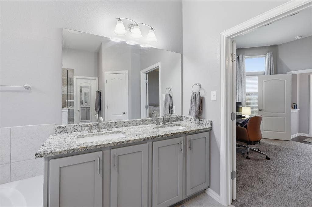 1556 Seminole Drive, Forney, TX 75126 Double vanity featuring granite countertops with dual sinks