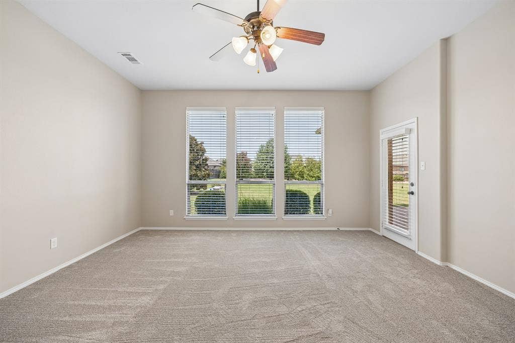 Large windows fill the room with natural light, creating a bright and tranquil owner's sanctuary. With access to the back patio, this primary suite offers an indoor/outdoor lifestyle.
