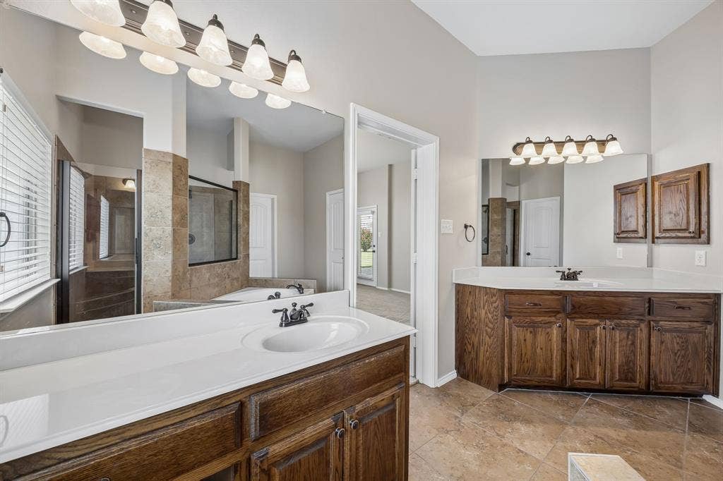 Luxury continues with separate vanities, rich wood cabinetry, extensive counter space, and elegant finishes throughout.