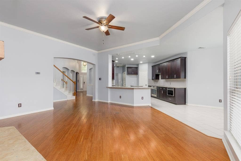 1913 Abilene Way, McKinney, TX 75072 Spacious living area featuring wood-finish flooring, a ceiling fan, and crown molding