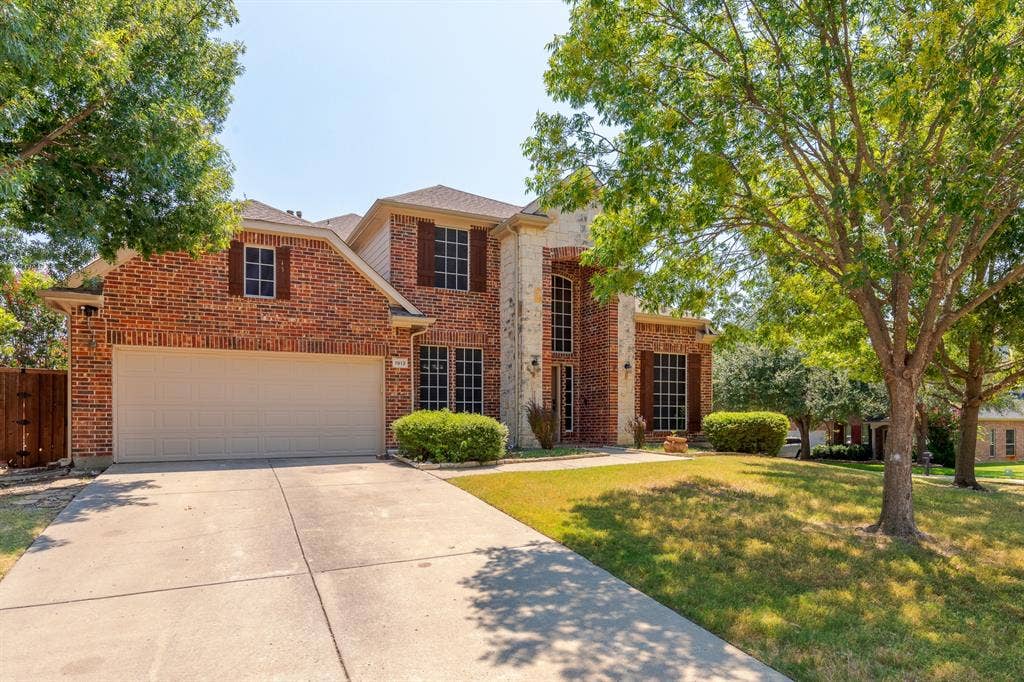 1913 Abilene Way, McKinney, TX 75072 Two-story traditional brick home featuring a two-car garage, multiple windows with dark shutters, and a covered entry