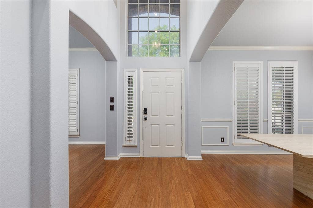 1913 Abilene Way, McKinney, TX 75072 Entryway featuring wood-finish flooring, a paneled front door with a transom window, and architectural archways