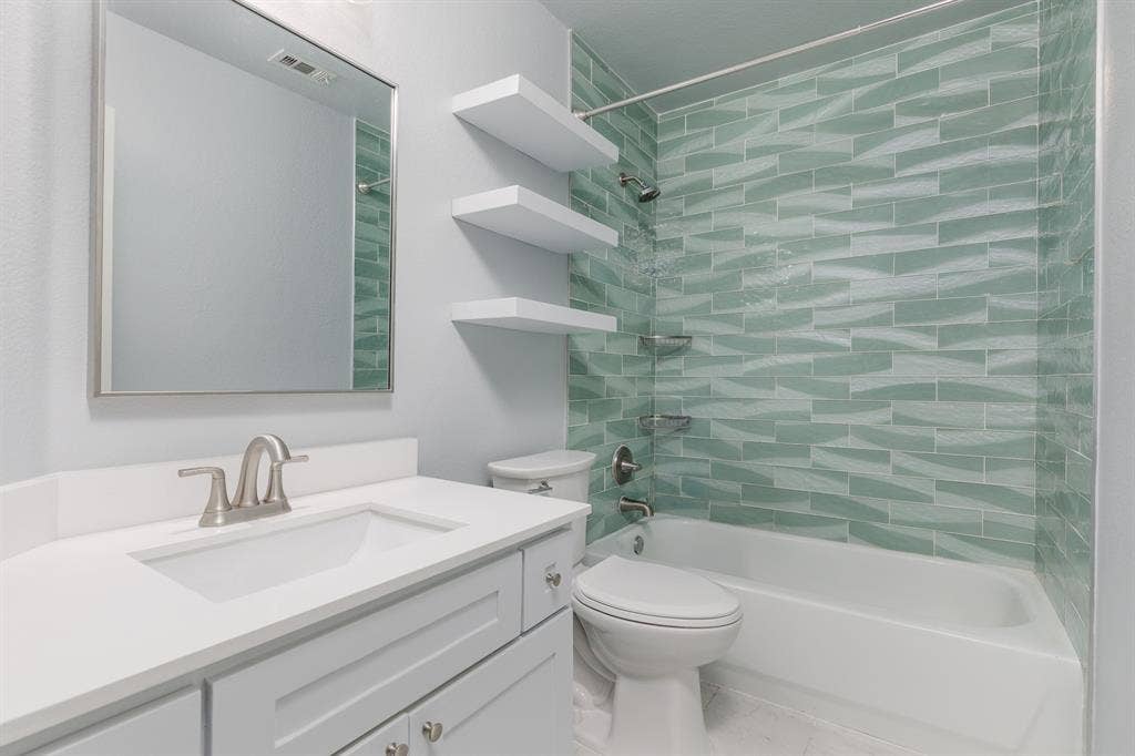 1913 Abilene Way, McKinney, TX 75072 Full bathroom featuring a vanity with an integrated sink, brushed nickel faucet, light gray cabinetry, and a framed mirror