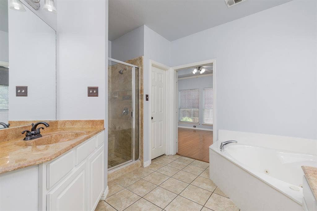 1913 Abilene Way, McKinney, TX 75072 Bathroom featuring a dual vanity with a stone-finish countertop, a glass-enclosed shower, a built-in jetted tub, and ceramic tile flooring