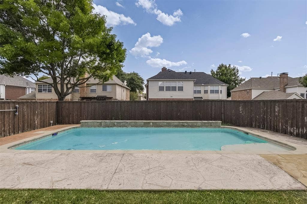 1200 Lakeway Drive, Plano, TX 75075 Rectangular inground pool with stamped concrete surround, stone coping, and a privacy fence