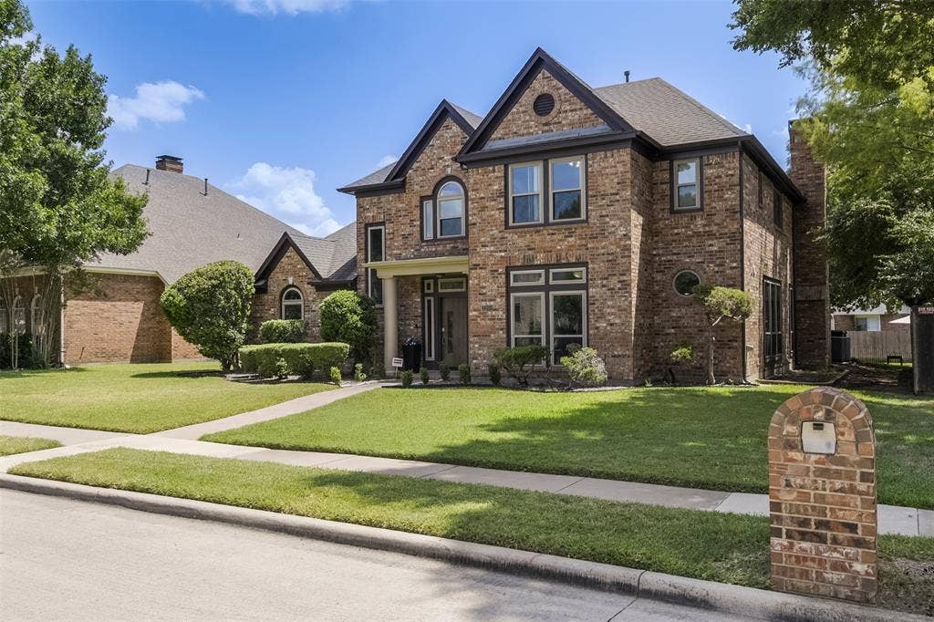 1200 Lakeway Drive, Plano, TX 75075 Brick exterior with dark trim windows, arched window accents, and a covered entry