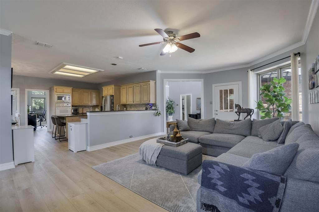 1200 Lakeway Drive, Plano, TX 75075 Expansive living area featuring wood-finish flooring, a ceiling fan, and crown molding