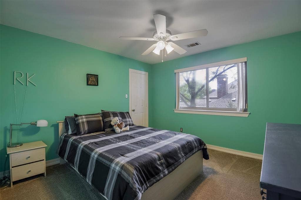 1200 Lakeway Drive, Plano, TX 75075 Recessed window with white trim, ceiling fan, white paneled door, and neutral-toned carpeting
