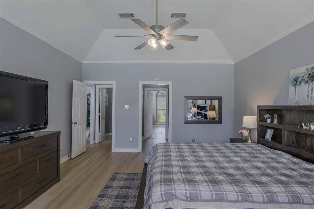 1200 Lakeway Drive, Plano, TX 75075 Vaulted ceiling with crown molding, wood-finish flooring, ceiling fan with integrated lighting, and multiple interior doorways