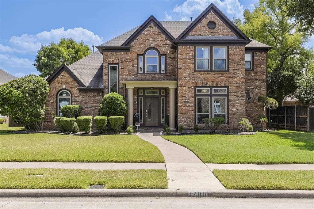 1200 Lakeway Drive, Plano, TX 75075 Brick facade residence with a gabled roofline, arched windows, and a covered entry