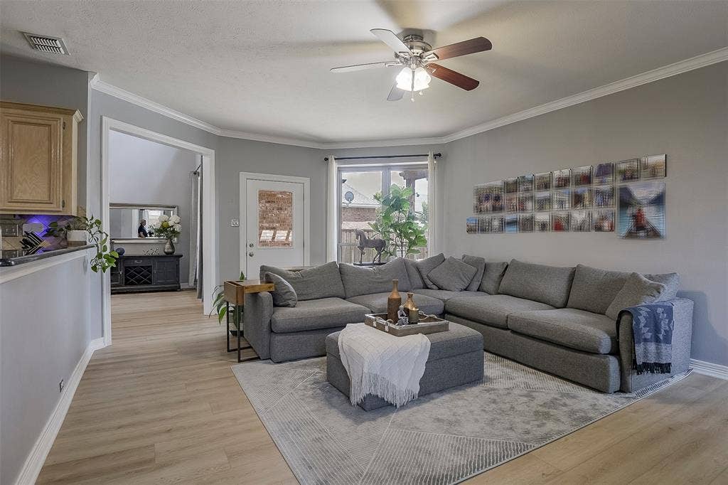 1200 Lakeway Drive, Plano, TX 75075 Light-toned wood-finish flooring, ceiling fan with integrated lighting, crown molding, and recessed lighting