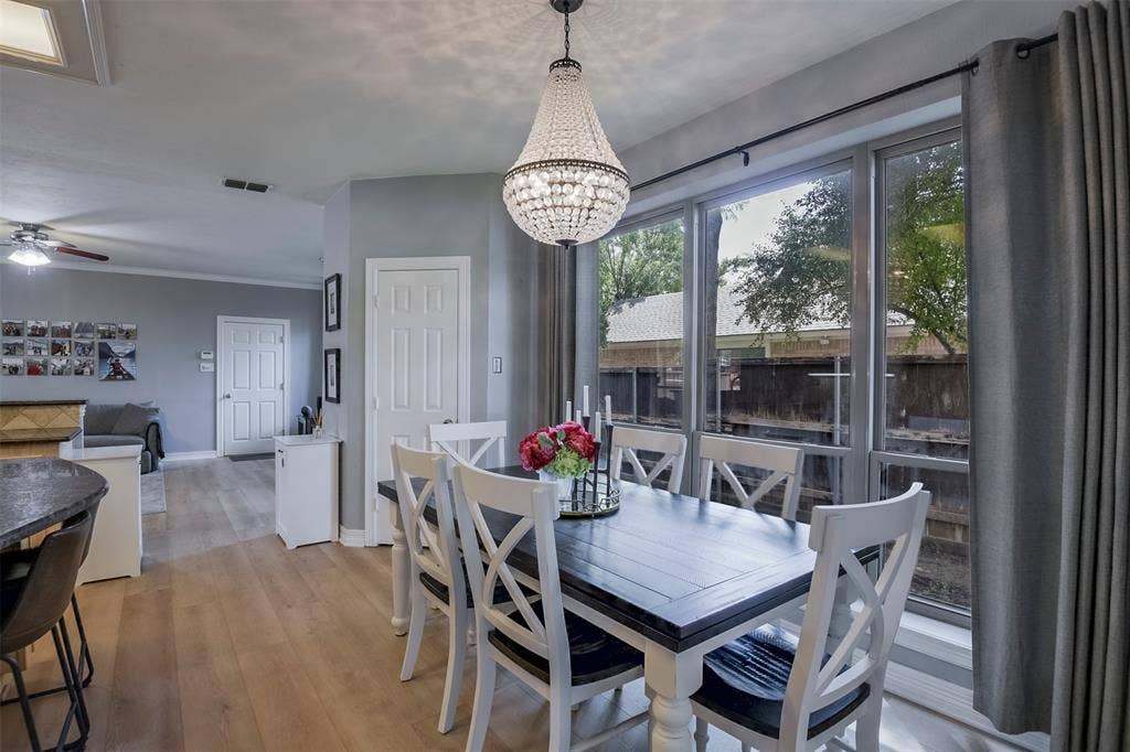1200 Lakeway Drive, Plano, TX 75075 Dining area featuring a crystal chandelier and large window with dark trim