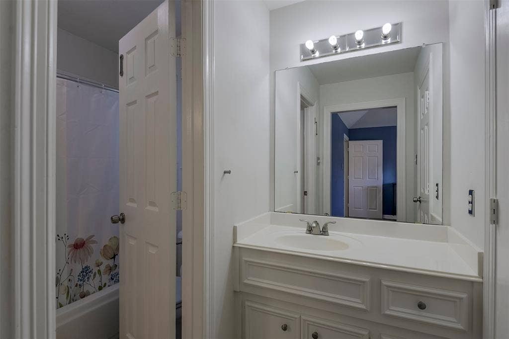 1200 Lakeway Drive, Plano, TX 75075 Vanity with an integrated sink, polished chrome faucet, and a large wall-mounted mirror