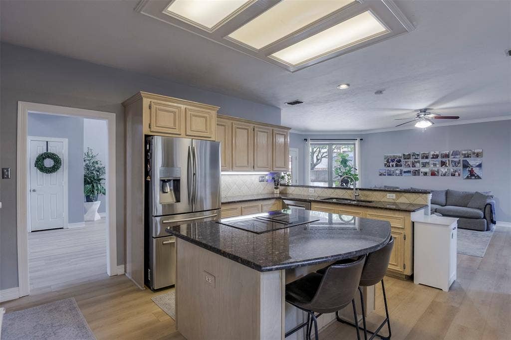 1200 Lakeway Drive, Plano, TX 75075 Kitchen featuring wood-finish cabinetry, granite countertops, tile backsplash, and stainless steel appliances